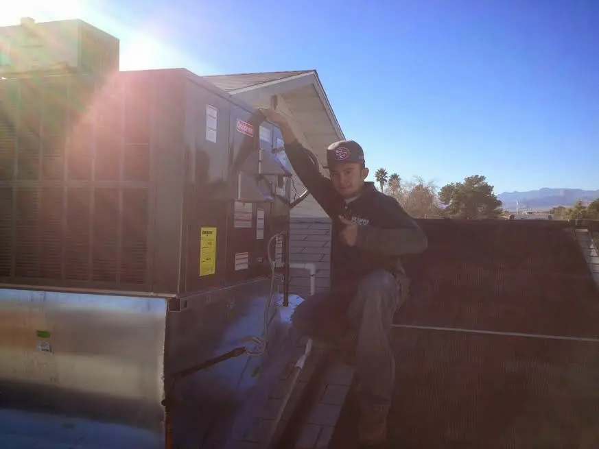 HVAC technician performing HVAC Inspection on a rooftop unit in Hastings